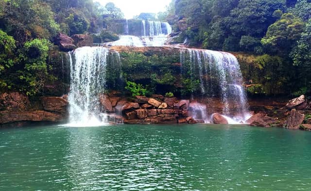 Meghalaya tourism showcasing living root bridges, Cherrapunji waterfalls, Dawki river, misty hills, and green landscapes