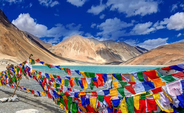 Ladakh tourism showcasing Pangong Lake, Nubra Valley sand dunes, Buddhist monasteries, and Himalayan landscapes